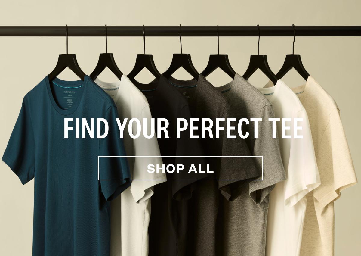 A row of Mack Weldon t-shirts hanging on black hangers