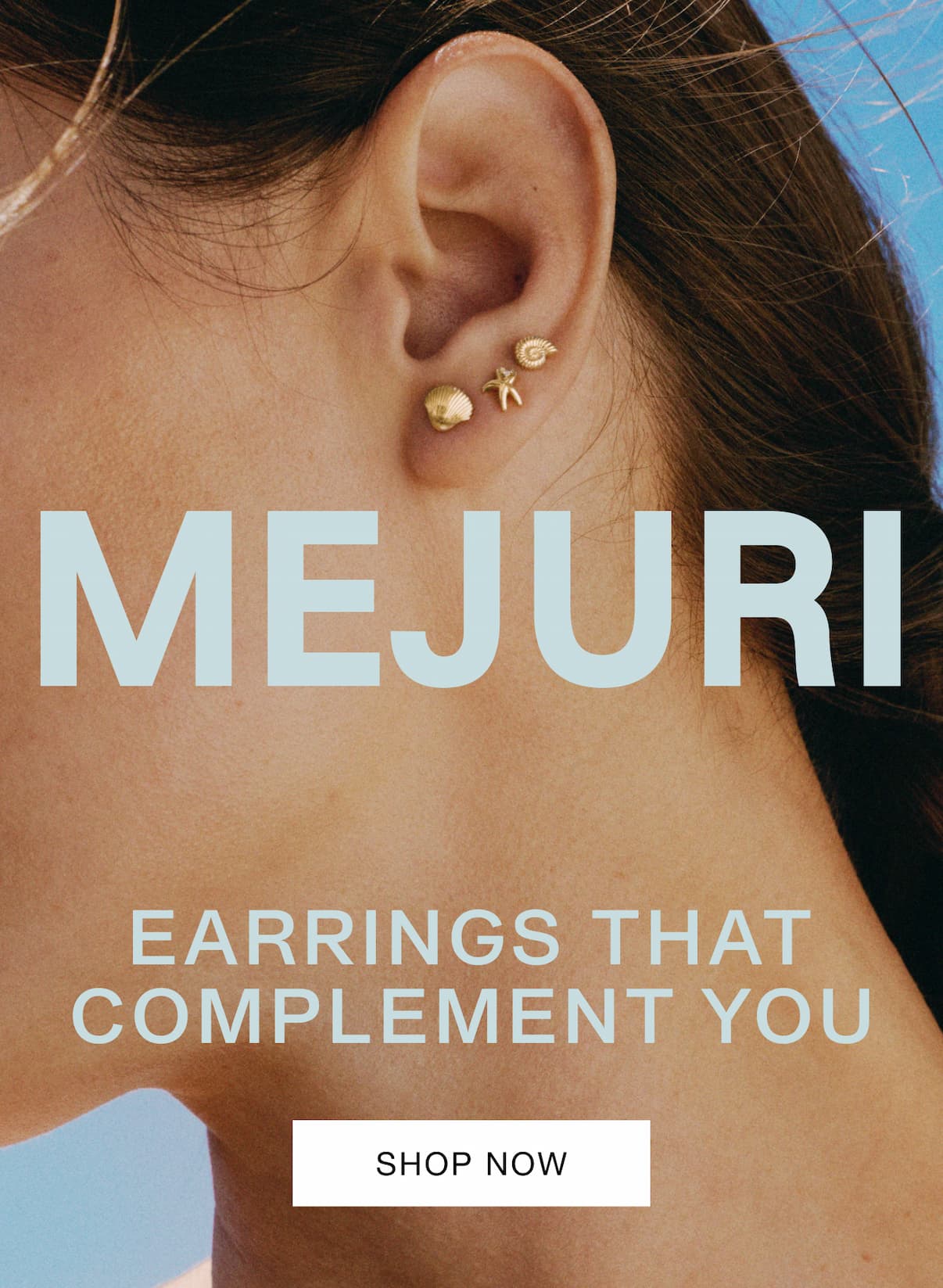 Close-up of a woman's ear wearing small Mejuri gold studs against a bright blue sky — Mejuri, Earrings That Complement You. Close-up of a woman's ear wearing small Mejuri gold studs against a bright blue sky — Mejuri, Earrings That Complement You.