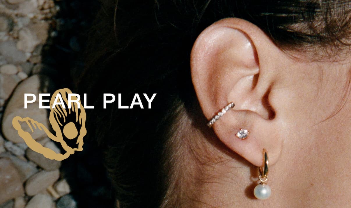 Close-up of a woman's ear wearing a Mejuri pearl huggie and diamond ear cuff — Pearl Play.