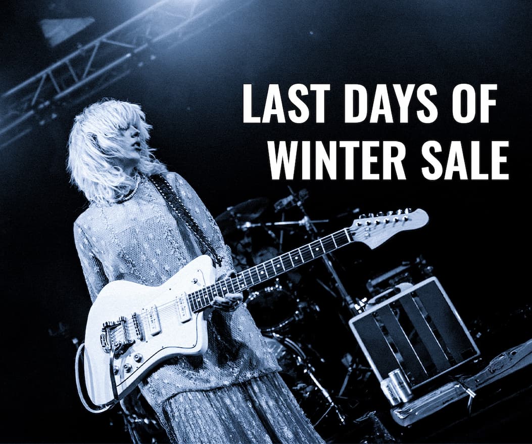 an image of a woman playing a guitar on stage with a microphone