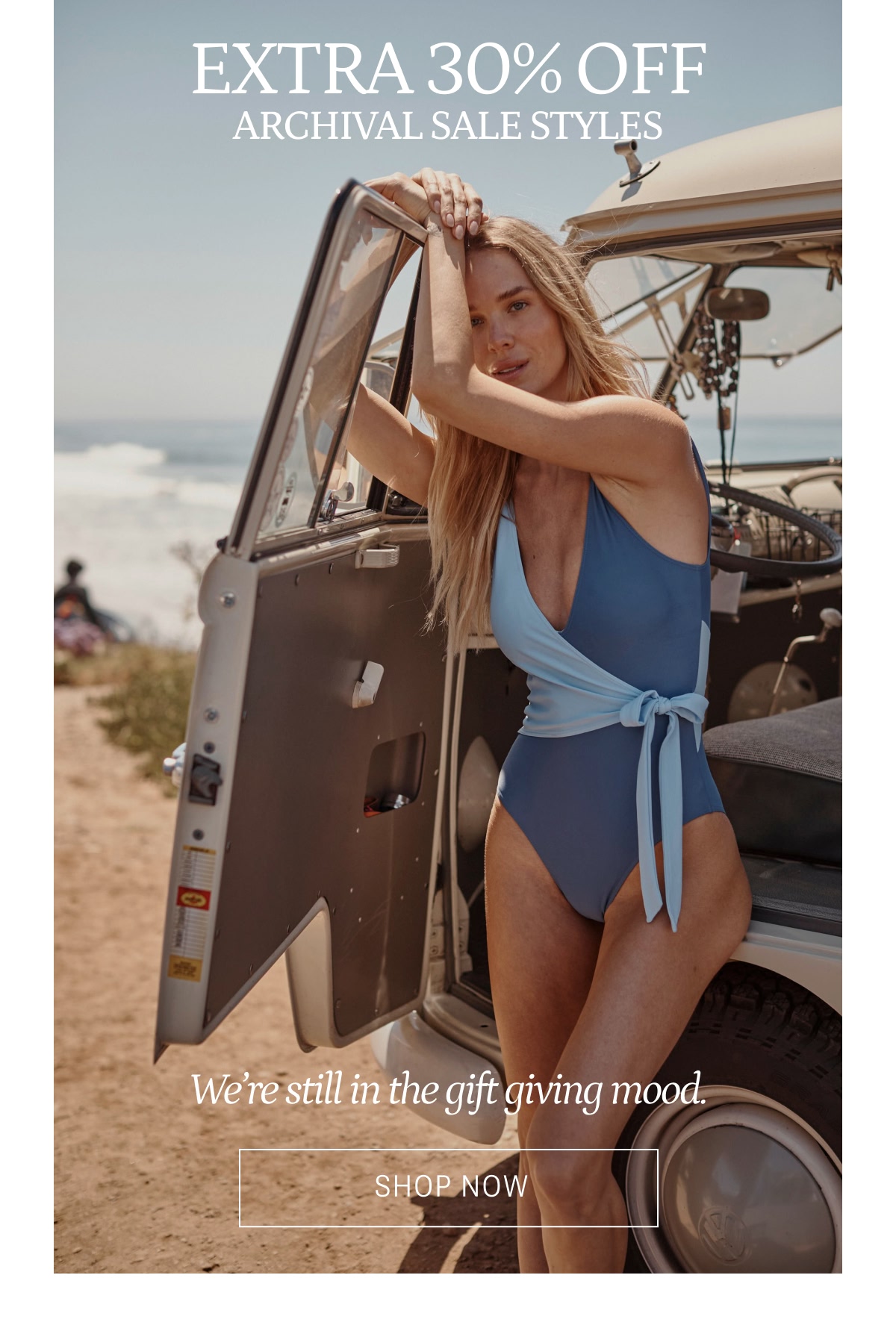 Model in blue and white wrap one piece swimsuit