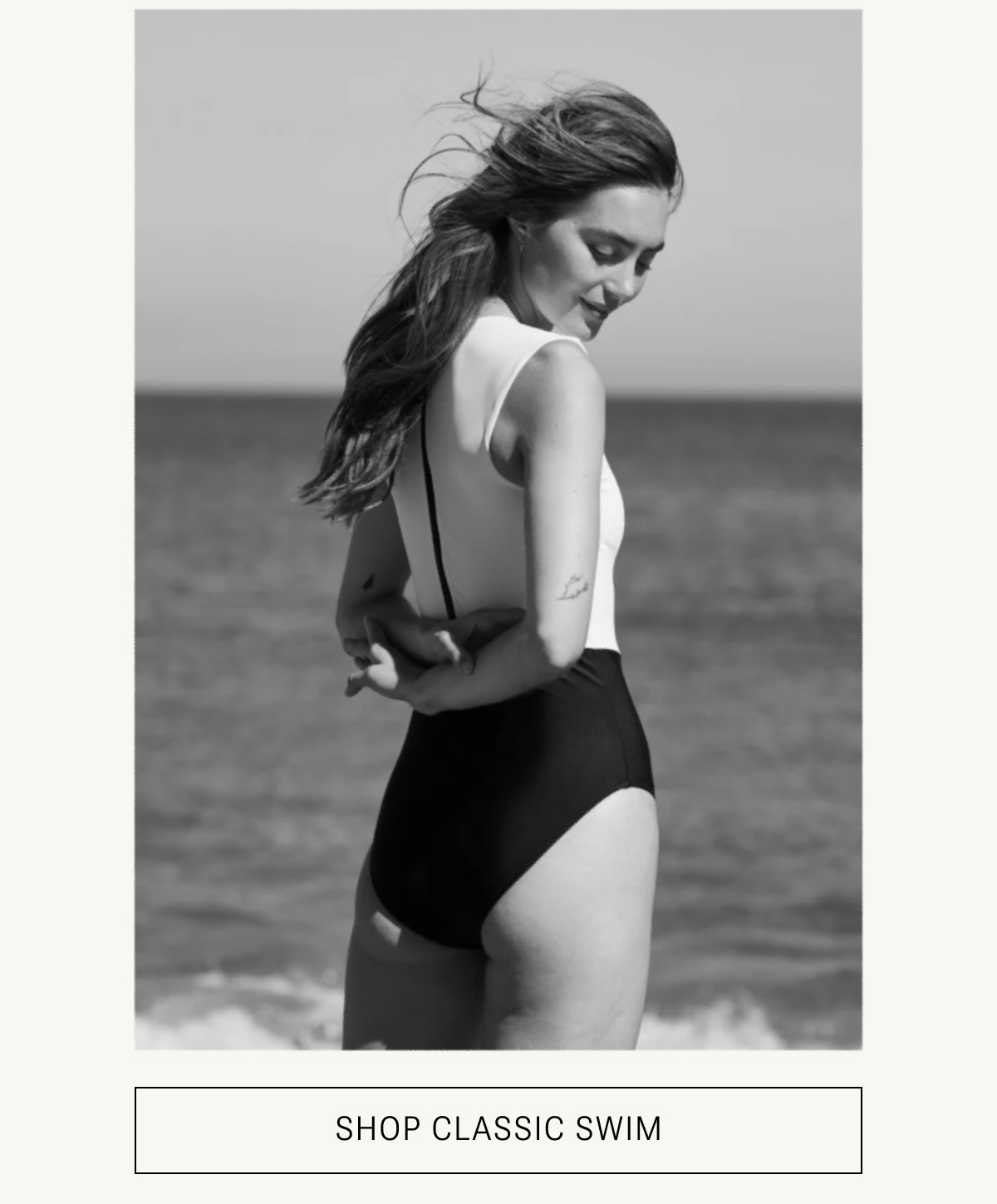 Model in black and white one piece swimsuit