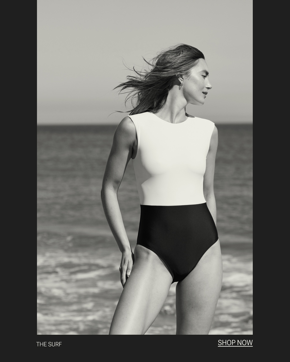 Model in black and white one piece swimsuit