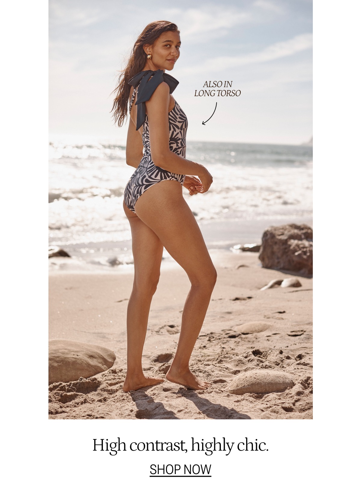 Model wearing an abstract palm print one piece swimsuit on the beach