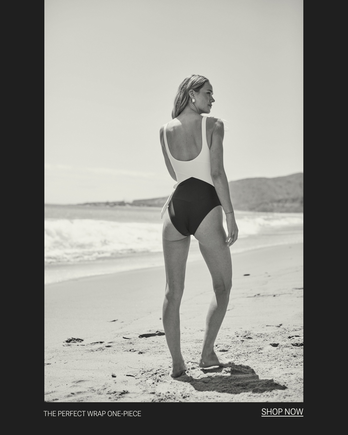 Model in black and white one piece swimsuit