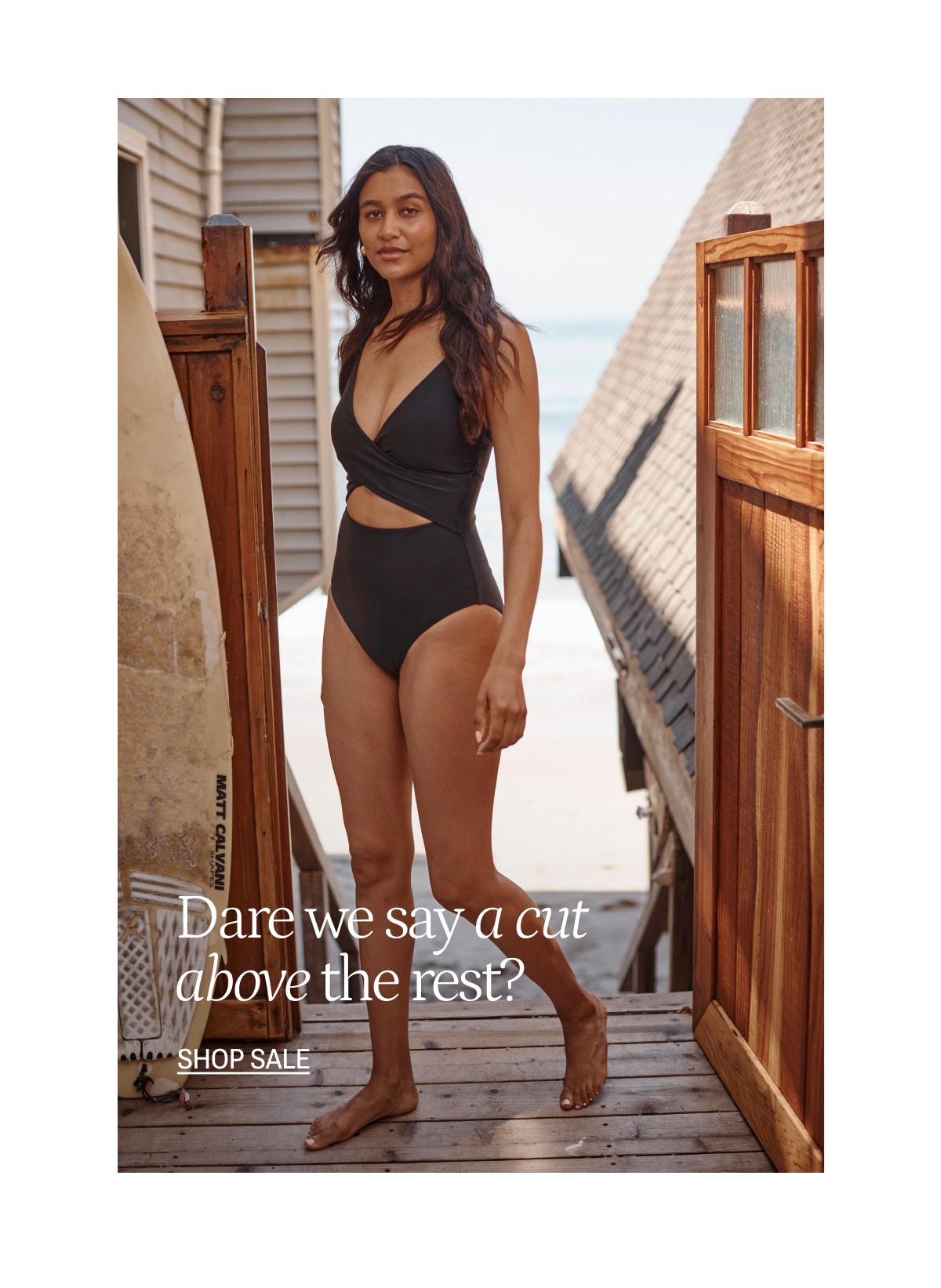 Model wearing a black cutout one piece swimsuit