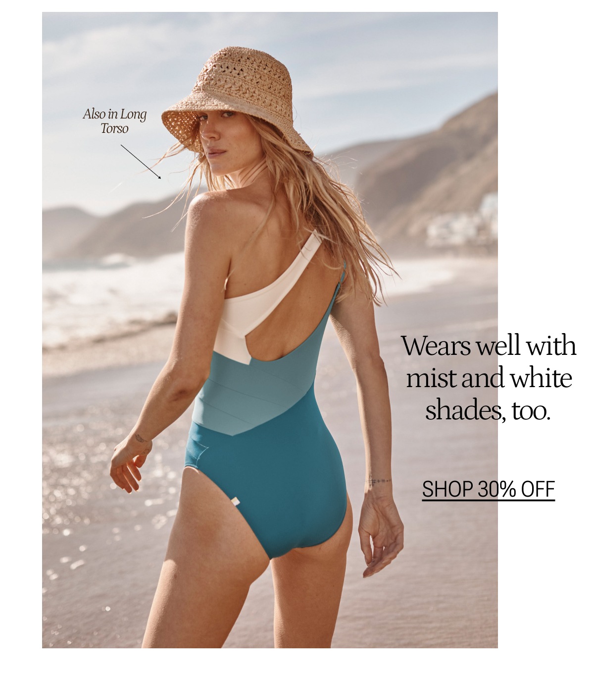 Model wearing a blue and white one shoulder one piece swimsuit on the beach