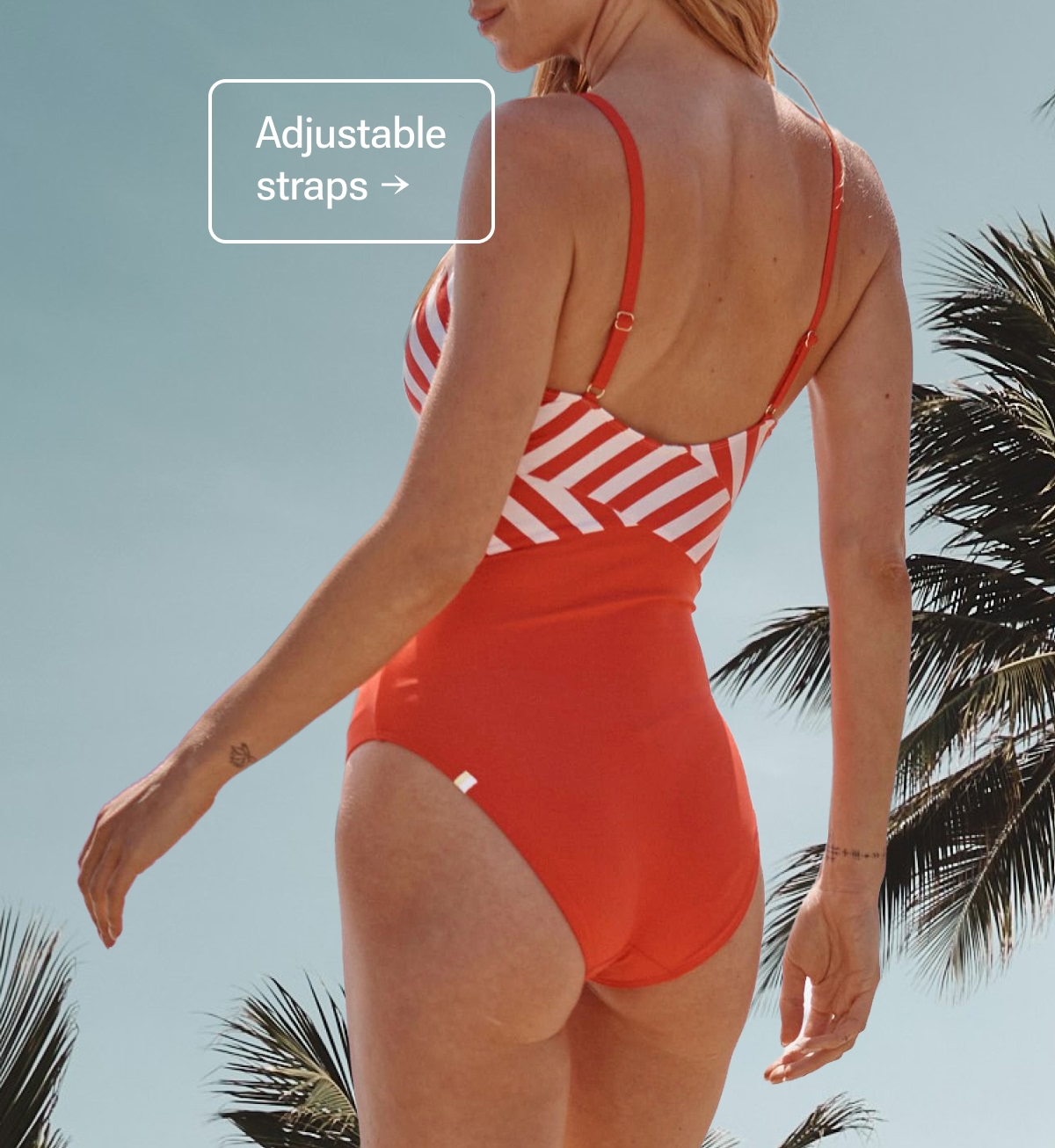 Model in orange and white striped cutout one piece swimsuit