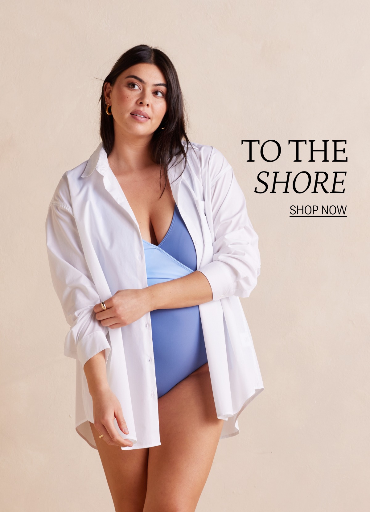 Model wearing a white button up shirt with one piece swimsuit