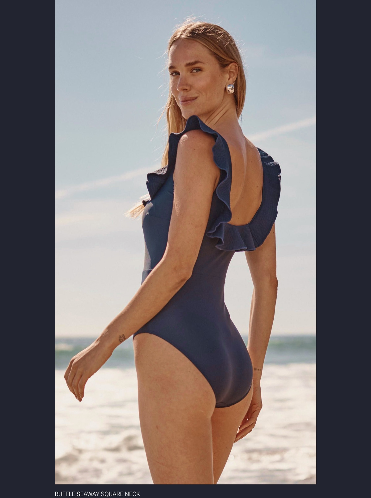Model in navy blue one piece swimsuit