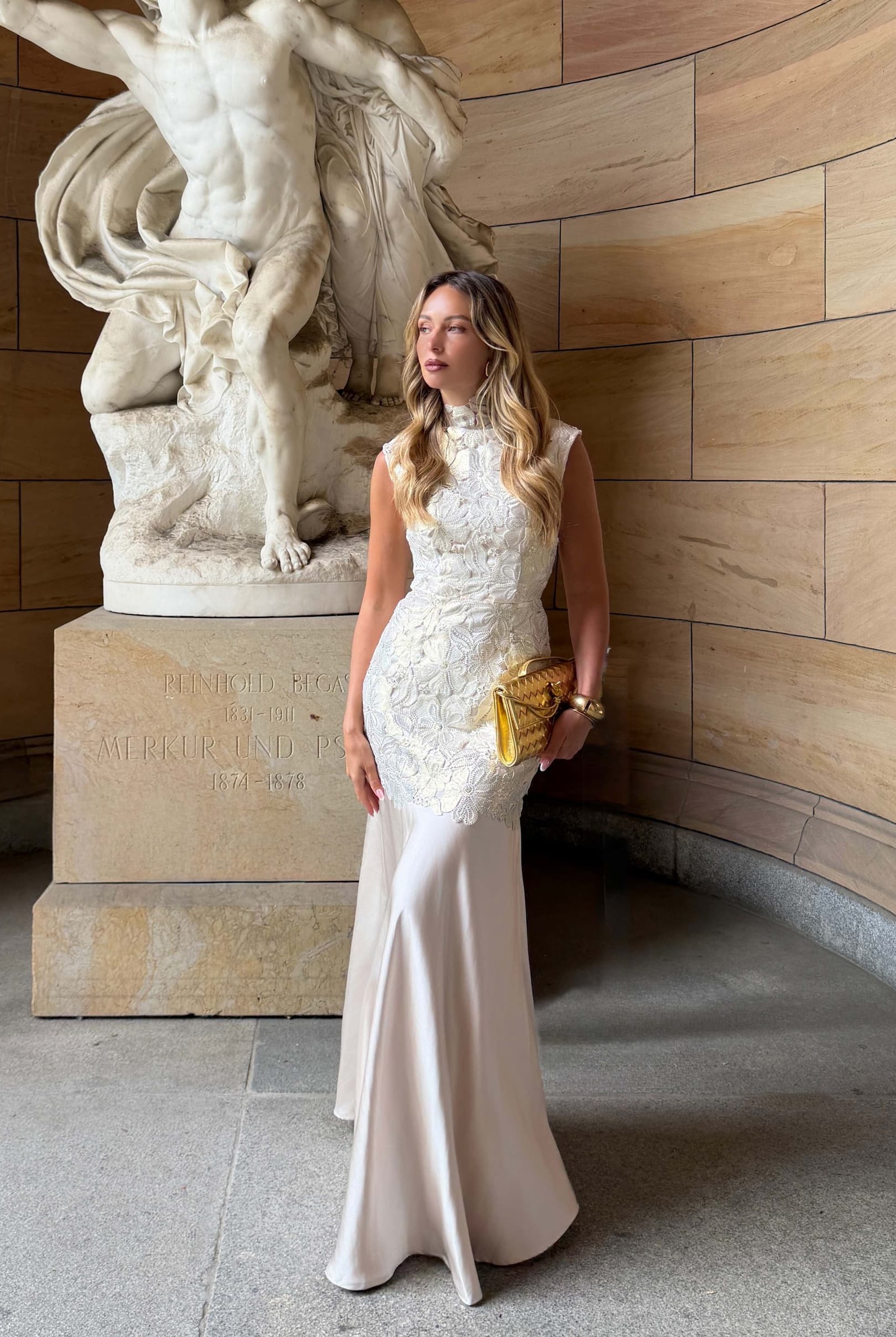 an image of a woman in a dress standing by a pillar