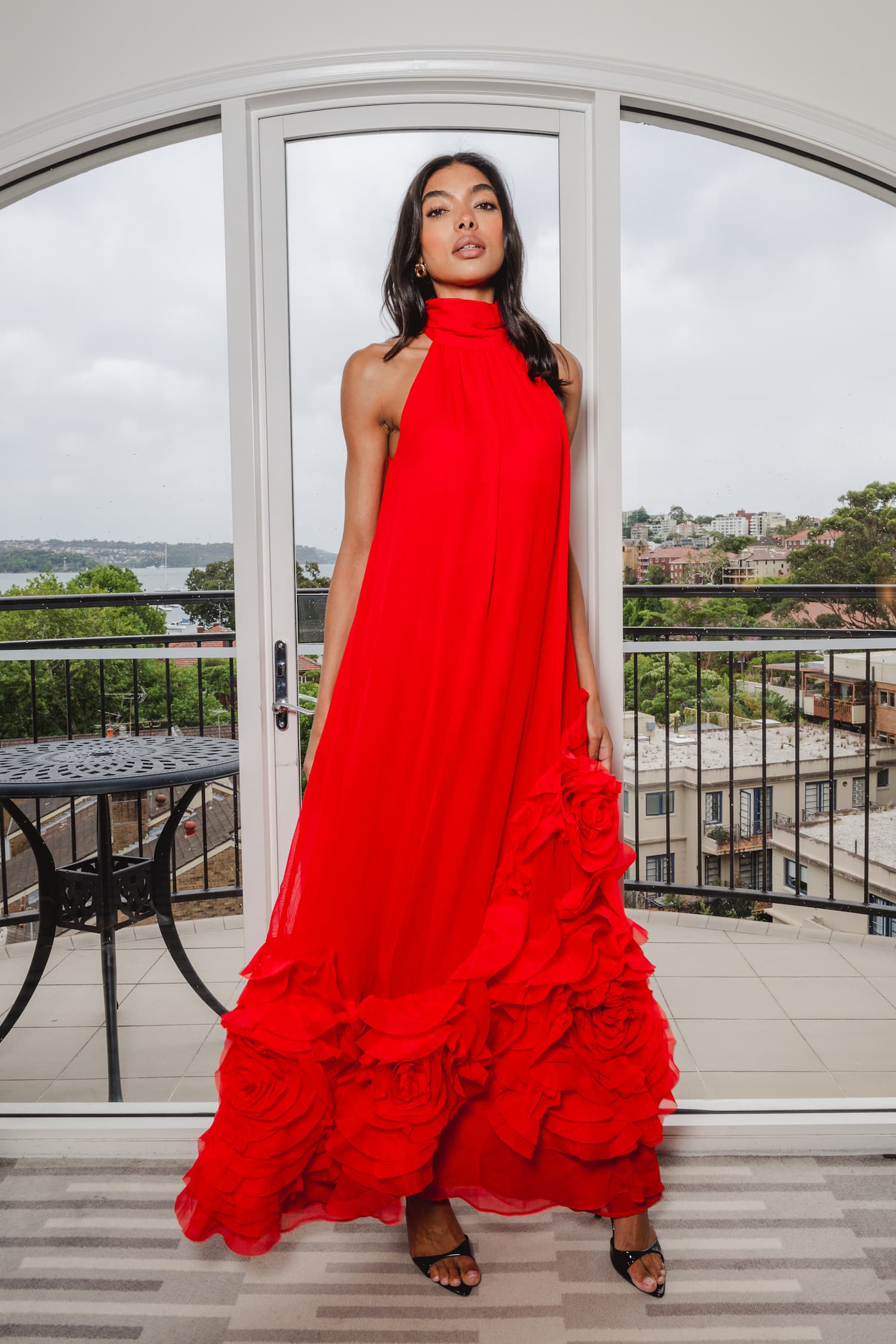 an image of a woman in a dress standing by a pillar