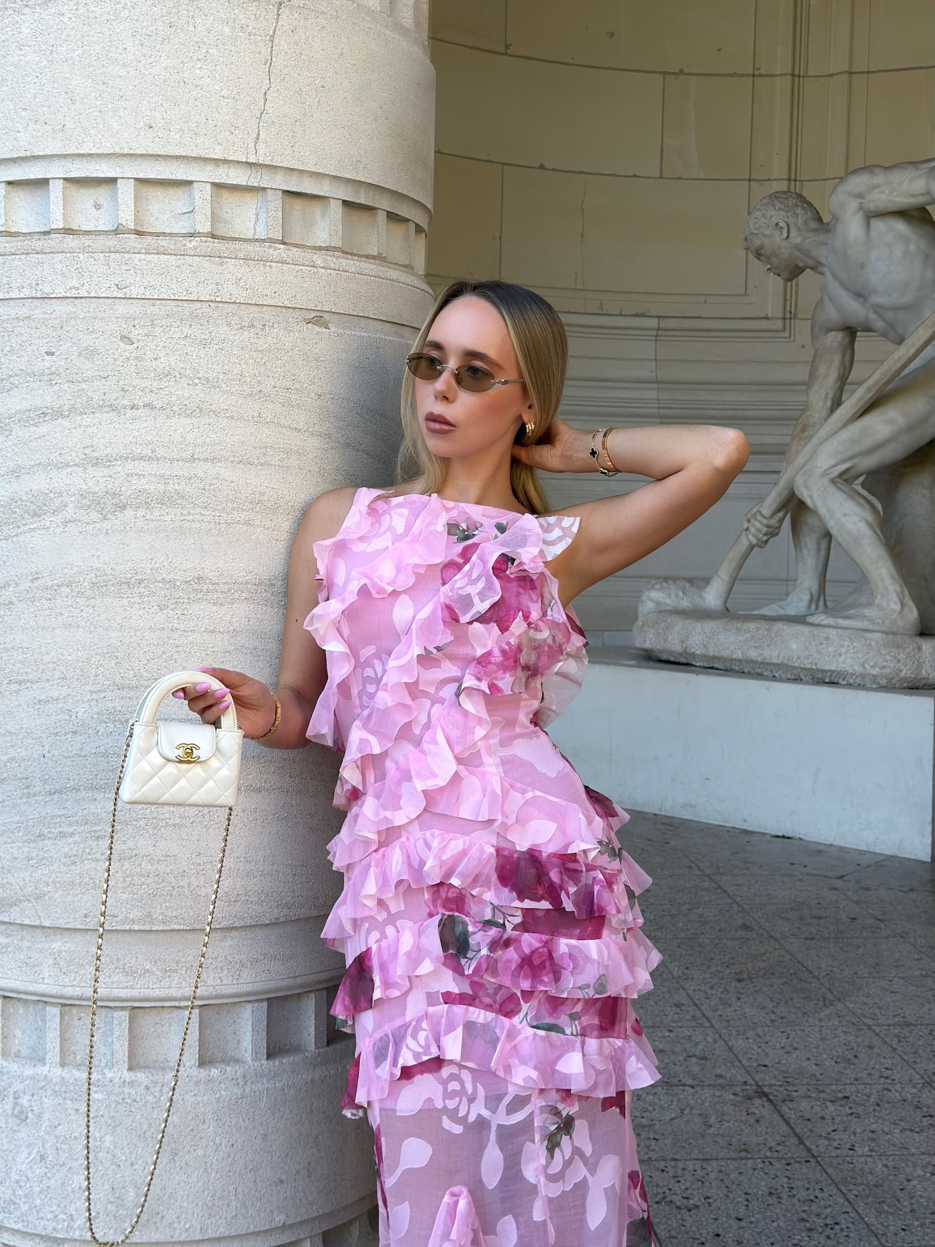 an image of a woman in a dress standing by a pillar