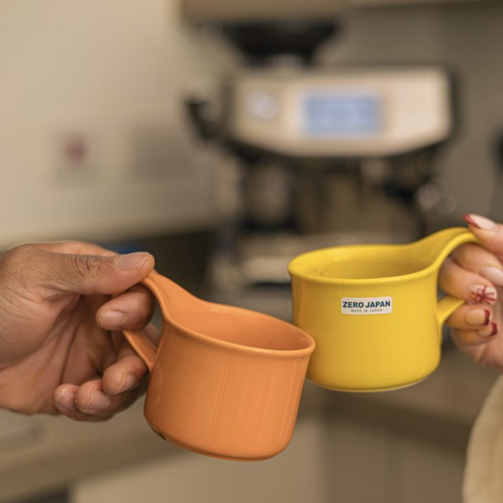 orange and yellow cup clinking