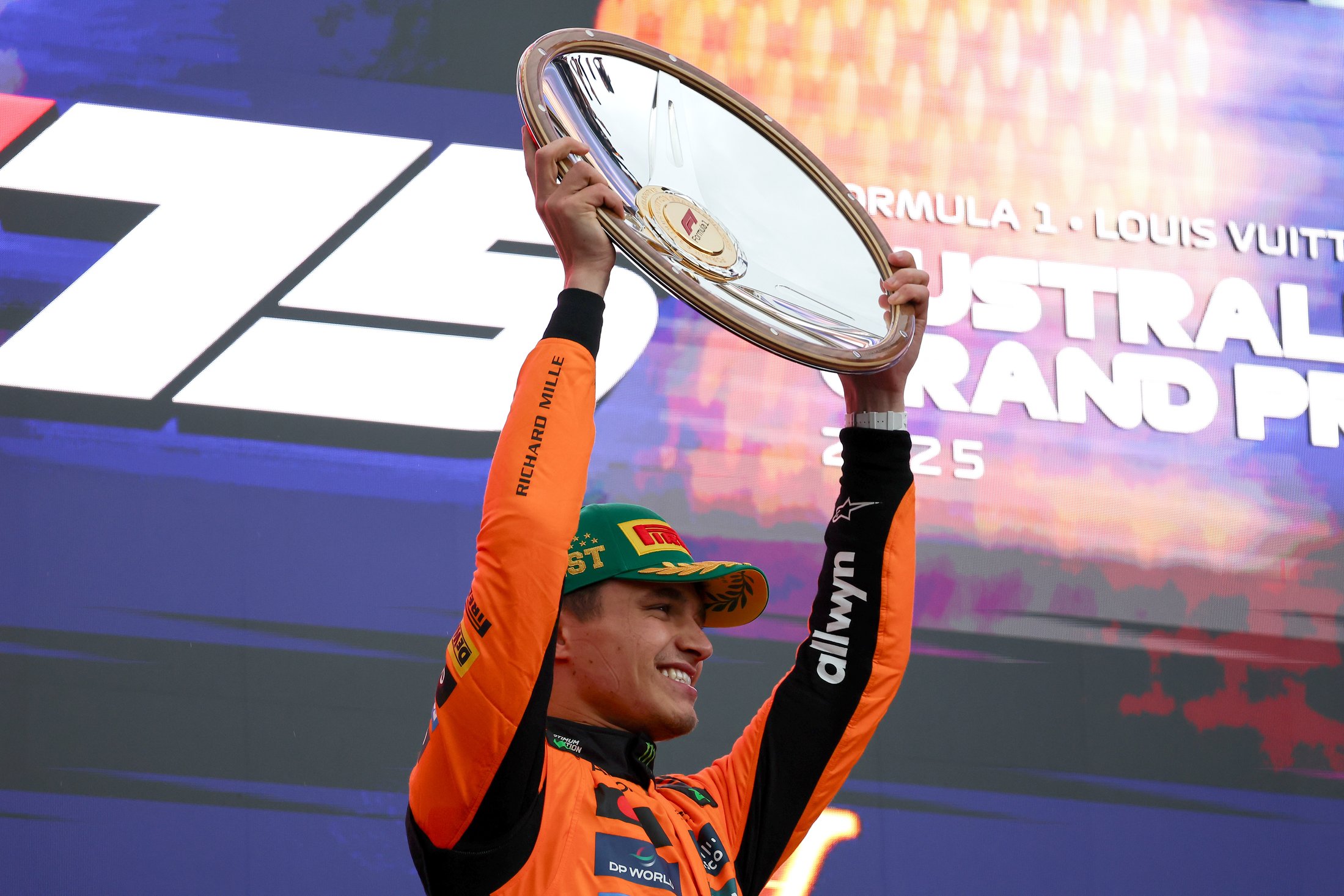 Lando Norris, McLaren, on the podium holding up his first place trophy for the Australian GP, 2025