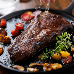 Strip Steak on plate with garlic and tomatoes
