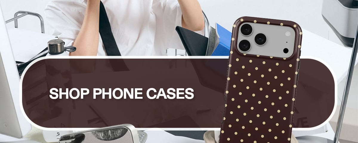 Woman at desk; brown polka dot phone case; Shop Phone Cases button