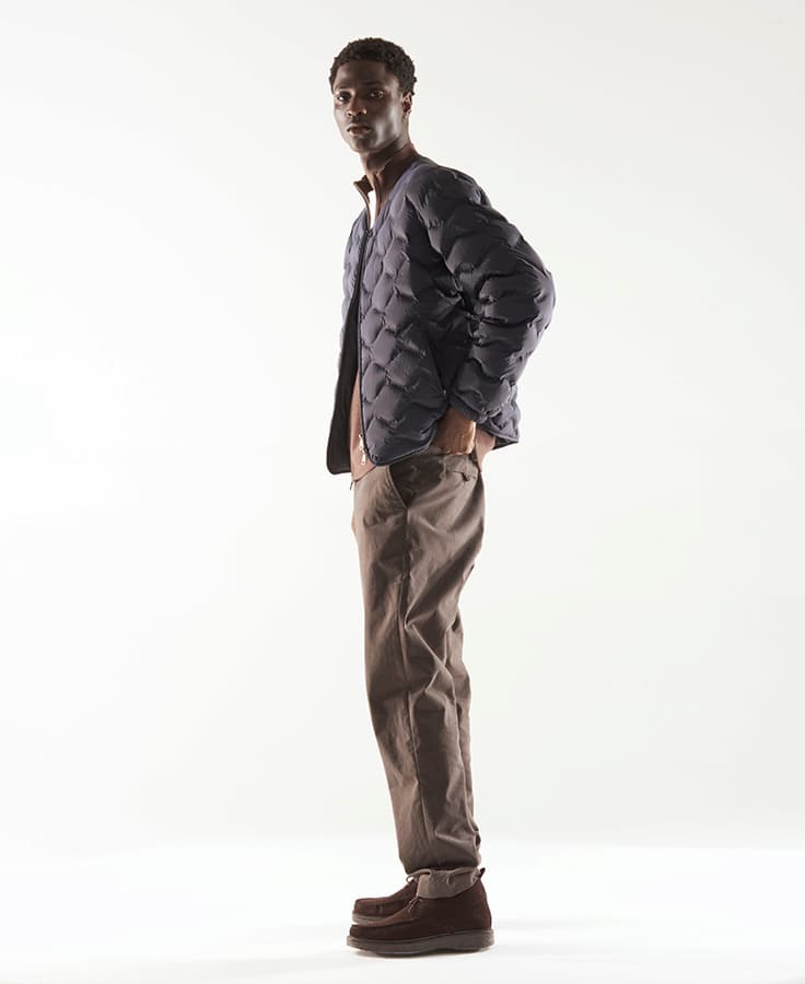 an image of a man standing in a studio wearing a jacket and pants