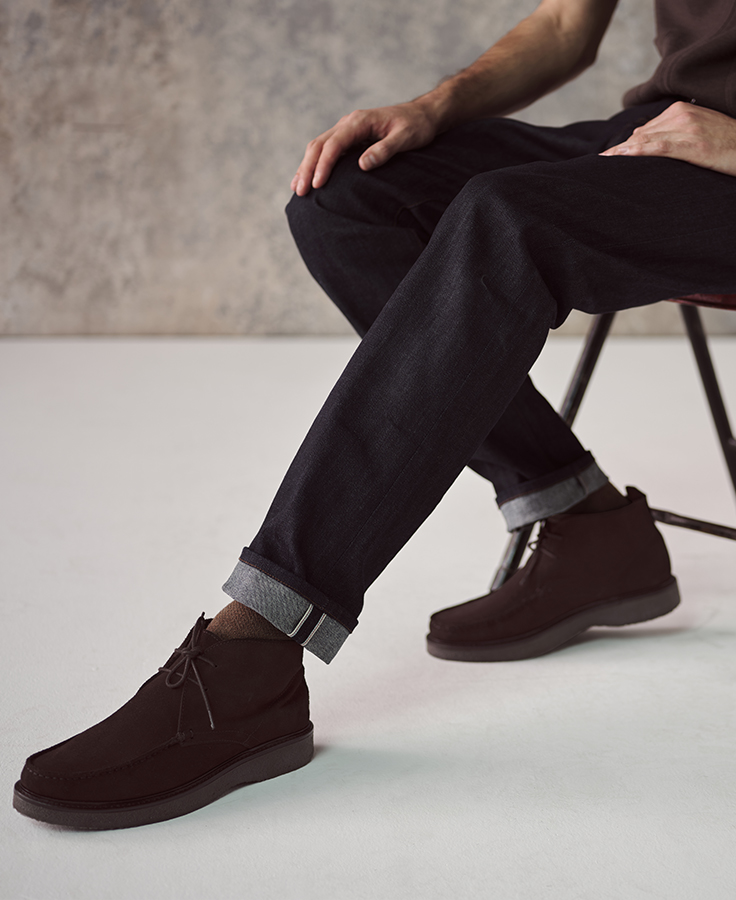 an image of a man sitting on a chair with his feet crossed