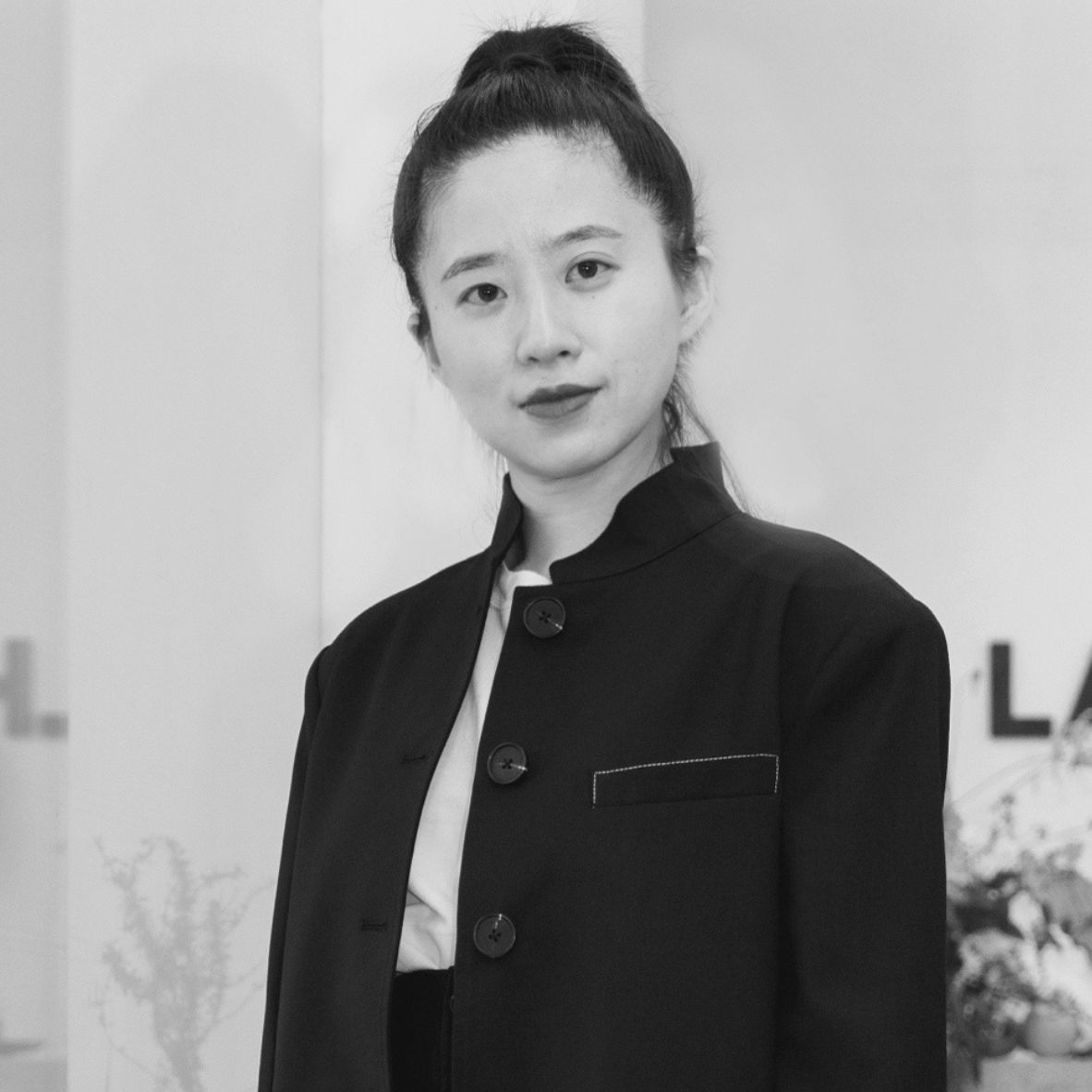 Black and white portrait of a smiling man in traditional clothing.