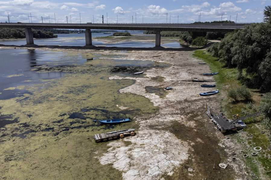 Boats and docks lay at the edge of a dried-up river bed.