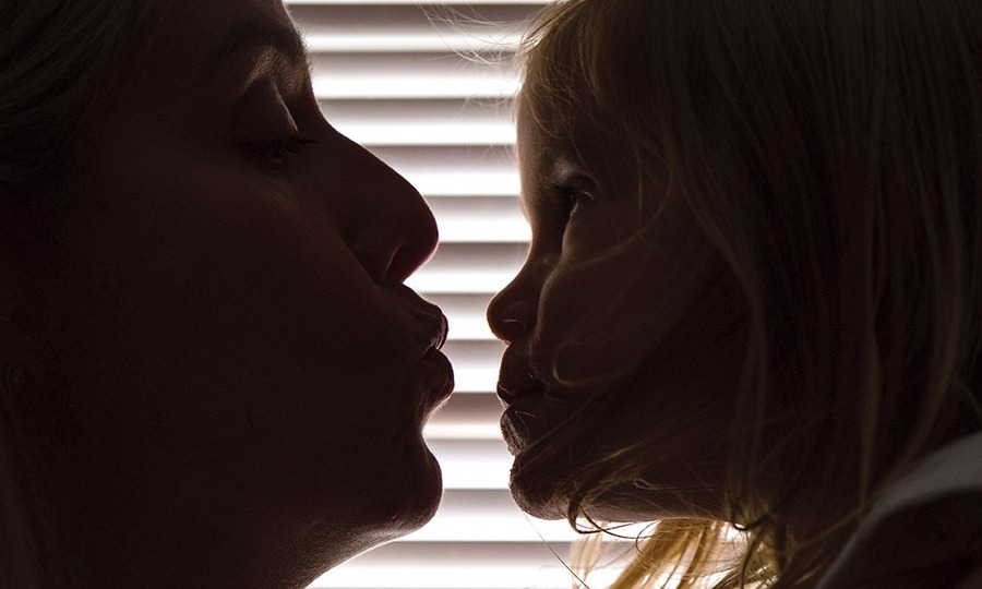 Kristina Leos (left), who went through severe depression after the birth of her daughter Victoria, leans in to kiss her child