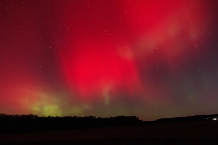 An image of two people holding metal detectors away from each other in a field outside