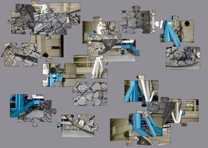 Blue, gray and white puzzle pieces arrayed on a light gray background.