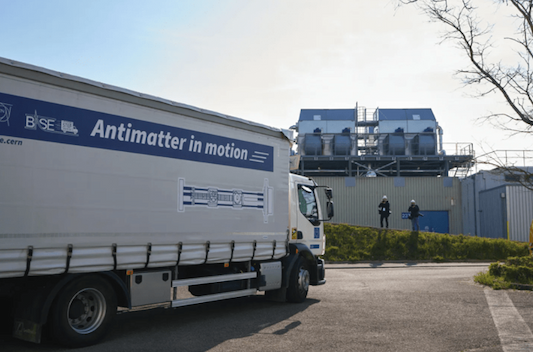 A white truck with the slogan "Antimatter in motion" drives in a parking lot