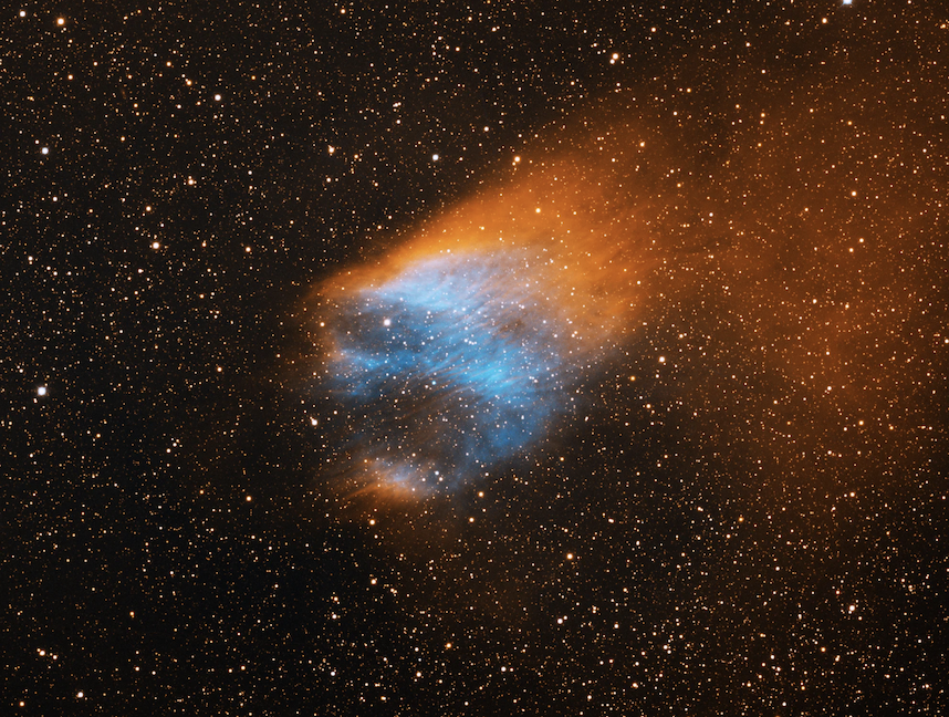 An image of Sh2-68, an ancient planetary nebula with a diffuse orange emission to the upper right, which is the result of the planetary nebula's motion through the disk of our galaxy. The bluish interior is from energized oxygen atoms. The progenitor star is the very blue star at the center of the bluish gas. 