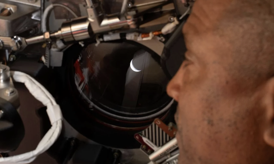 NASA Astronaut Victor Glover looking out at Earth through capsule