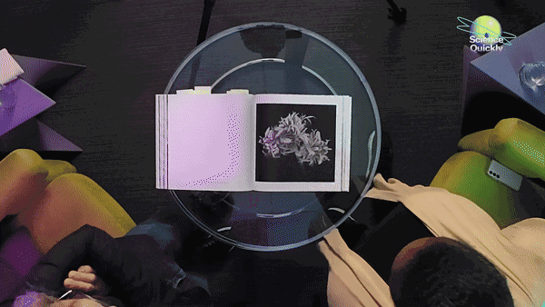 A GIF showing an overhead view of a book opened to a black and white image, and then zooming in on a microscopic creature in black and white.