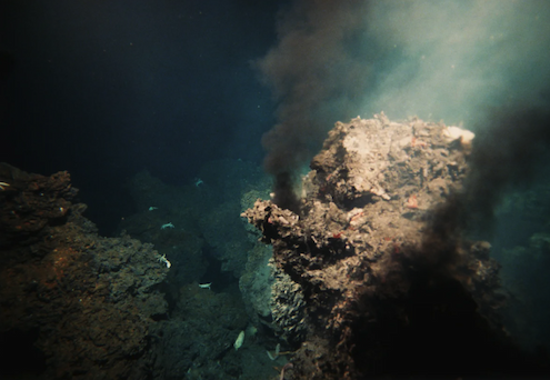 Undersea image of a deepsea hydrothermal vent in a beam of light.