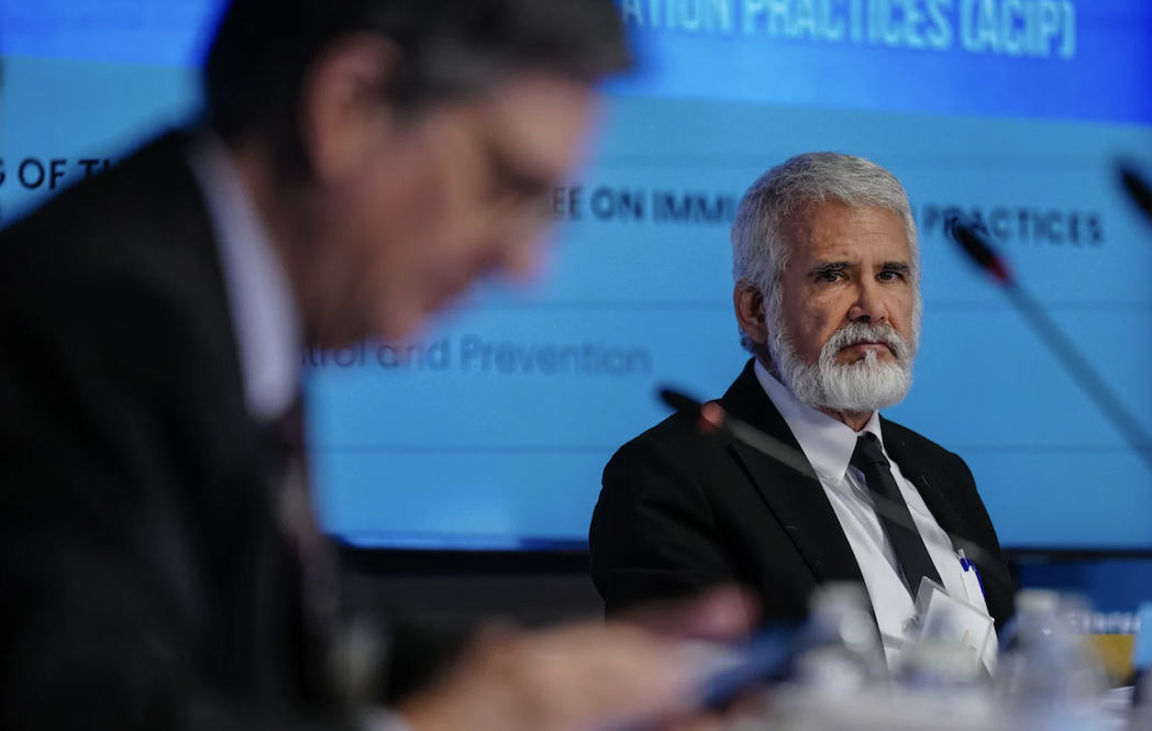 A photo of a man on a panel event looking concerned.