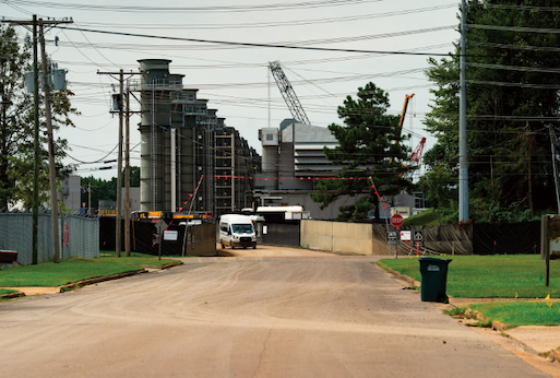 Gas turbines rise at the end of a residential street.