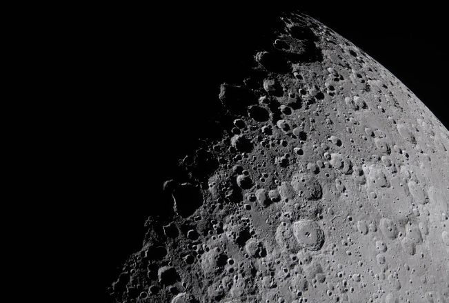 The craters on the moon in sharp relief where the shadow of the moon and the light meet