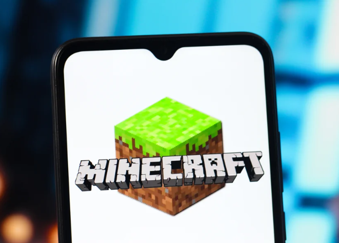 A closeup on a smartphone screen shows the Minecraft logo