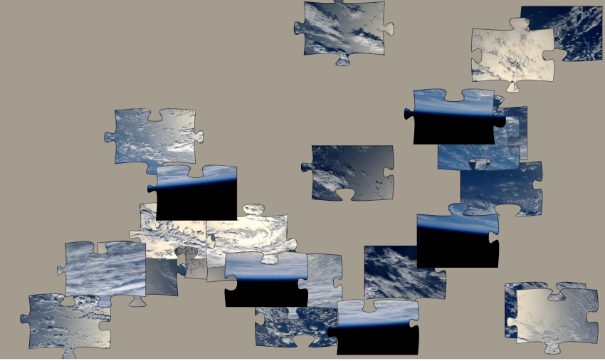 Blue, gray and white puzzle pieces arrayed on a light gray background.