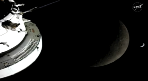 A view from outside the Orion capsule of the moon and a crescent of Earth in the distance