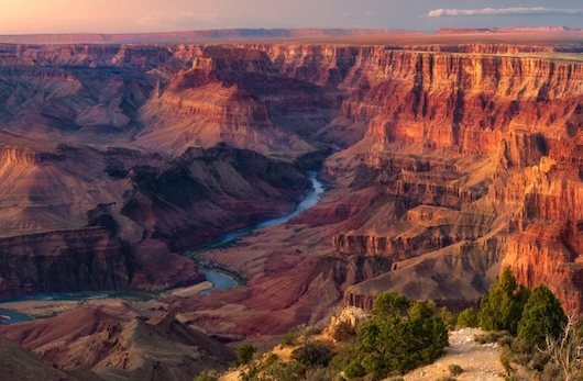 The colorful walls of the Grand Canyon at sunset, with the Colorado River flowing through