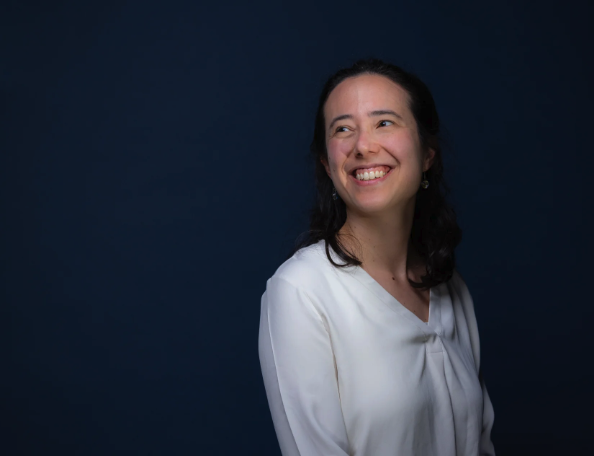 A portrait photo of Anna Ho smiling and looking off camera