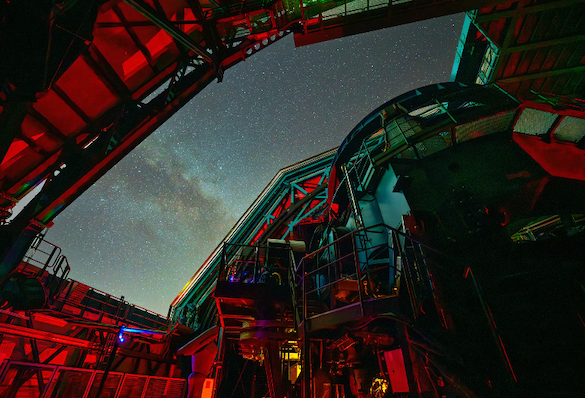 Rubin Observatory's massive telescope pointed upward toward the night sky visible through the rectangular dome opening