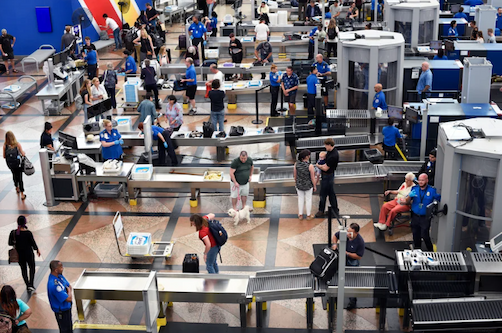 Airplane passengers proceed through a TSA security checkpoint