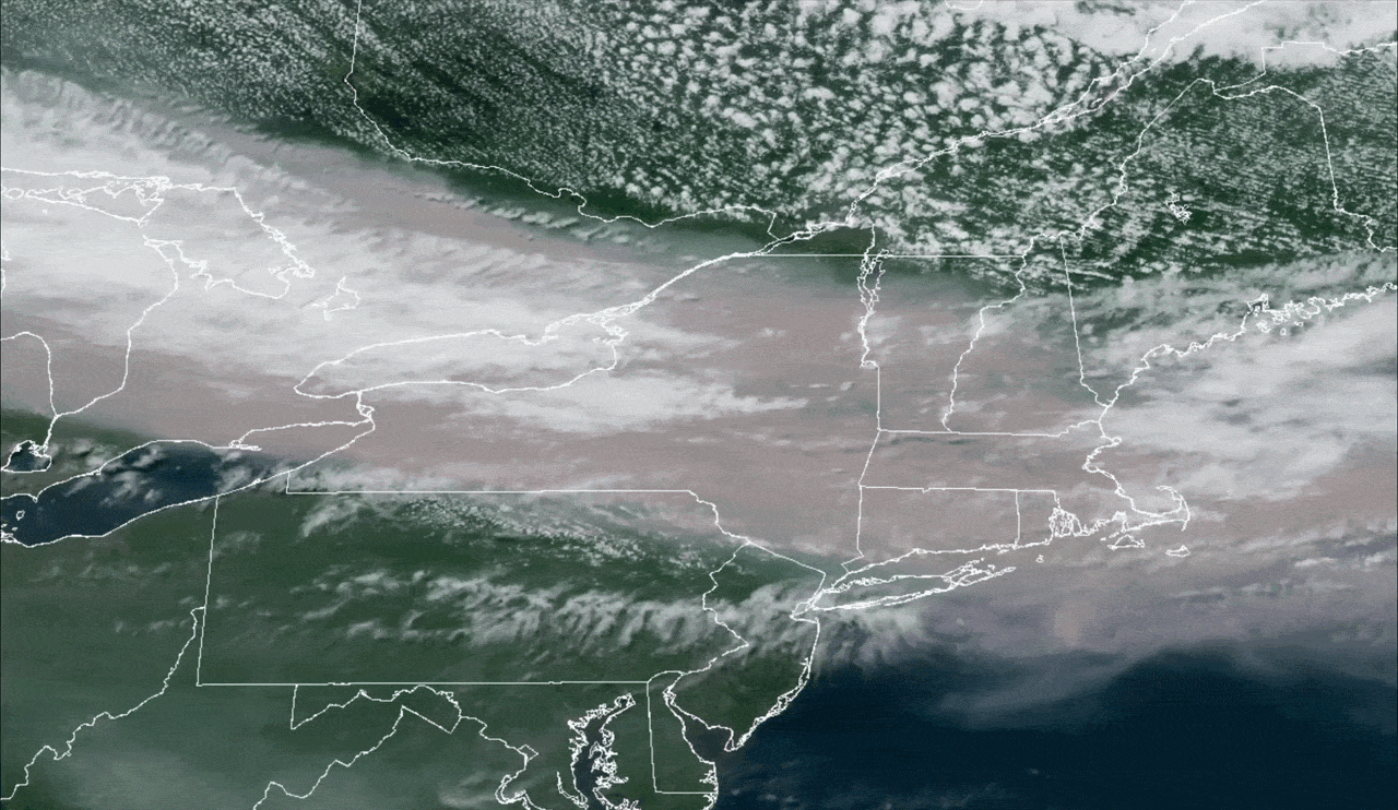 A gif of a satellite image showing a river of brown smoke over the northeastern US