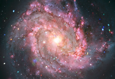 A pink and purple spiral galaxy with a bright glowing center