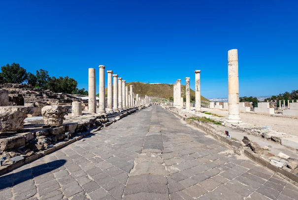 A stone walkway flanked by ancient columns and other ruin-like structures.