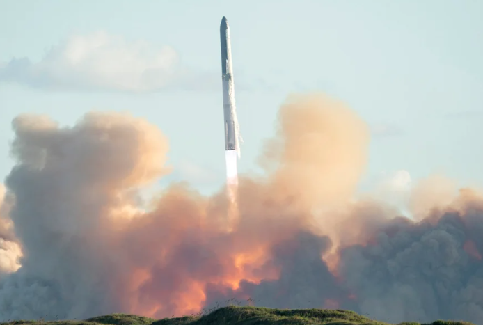 A tall, white rocket launches above firey clouds