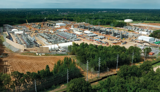 Aerial view of a large power plant surrounded by trees
