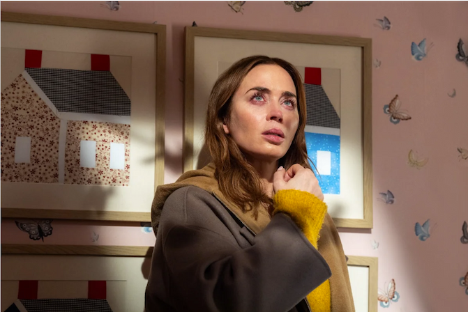 A woman who looks like she's just finished crying looks up in a child's bedroom