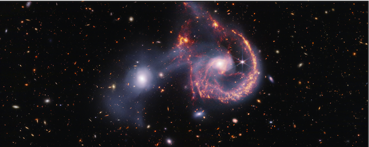 Two galaxies are shown mid-collision against a background of more distant galaxies.